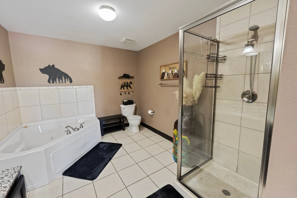 A tranquil, spa-inspired bathroom showcasing a modern bathtub and a walk-in shower. The soothing decor includes soft lighting, decorative wall art, and inviting fixtures, creating a space ideal for relaxation and rejuvenation after an exciting day.