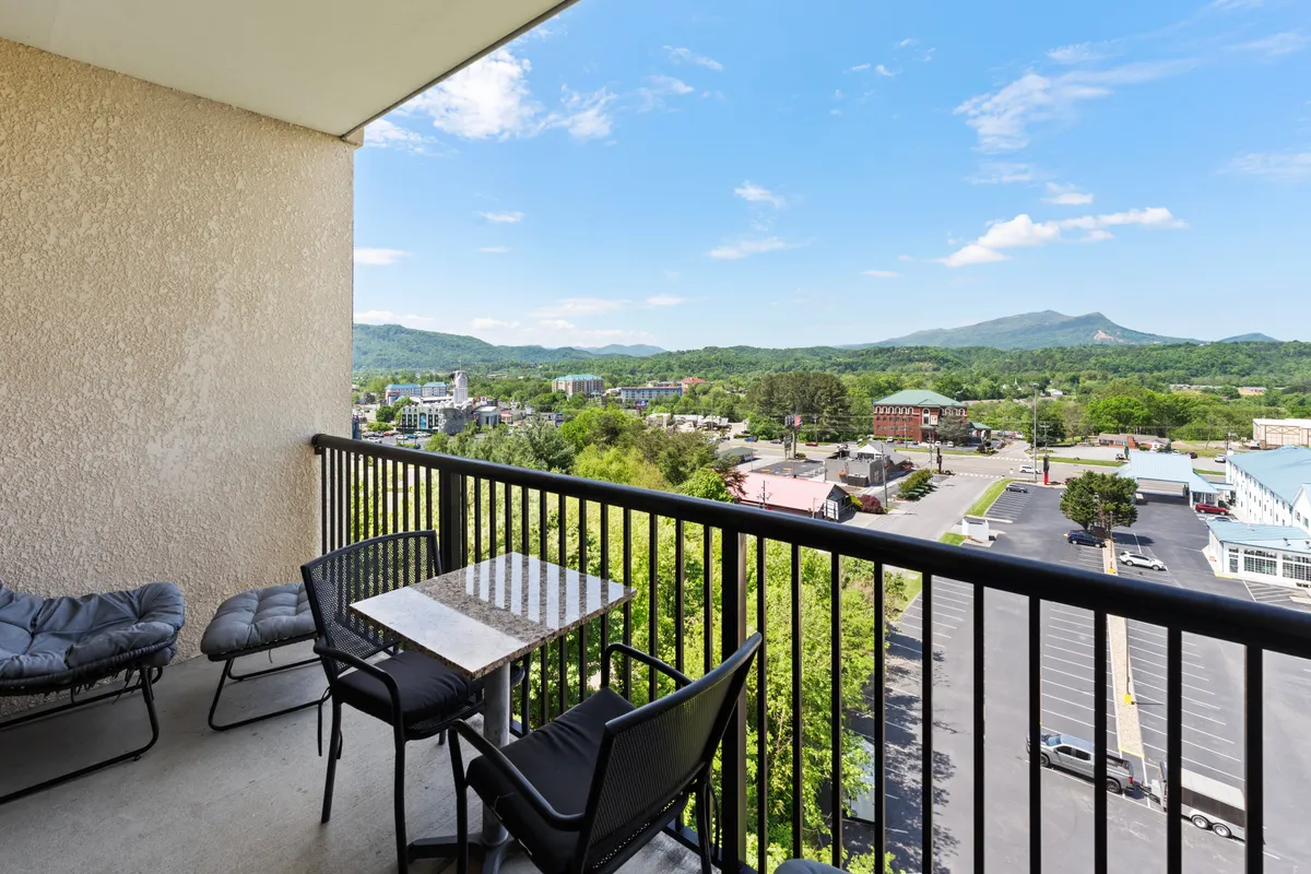 A scenic balcony view featuring comfortable furniture, a sweeping mountain backdrop, and a glimpse of the lively town below. Ideal for morning coffee, relaxing with friends, or planning the day’s adventures.